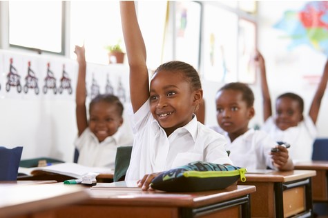 Children raising hands in a classroom