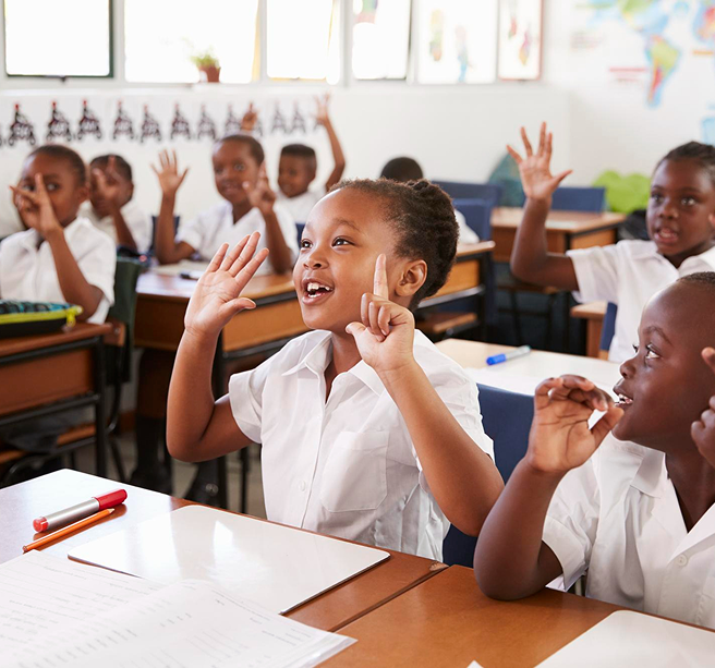 Children raising hands in a classroom